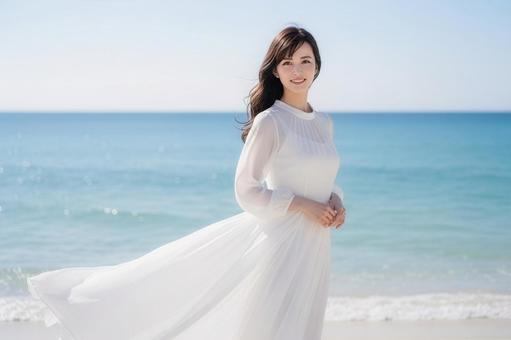 海辺に立つ笑顔の女性 美容CMワンシーンの写真