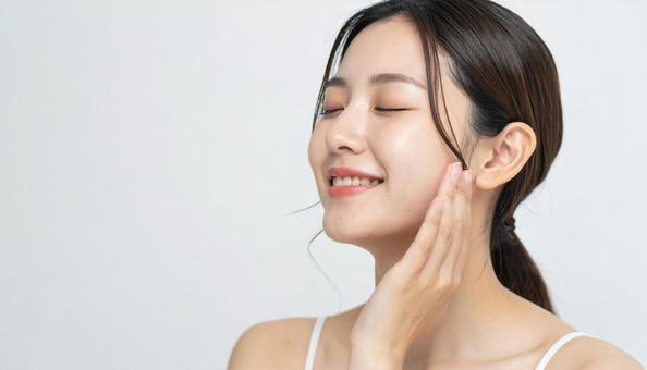 ほほをさわり満足して目をつむる若い女性 ほほをさわり満足して目をつむる若い女性の写真