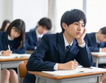 授業中に考え事をする男子高校生 授業中に考え事をする男子高校生の写真