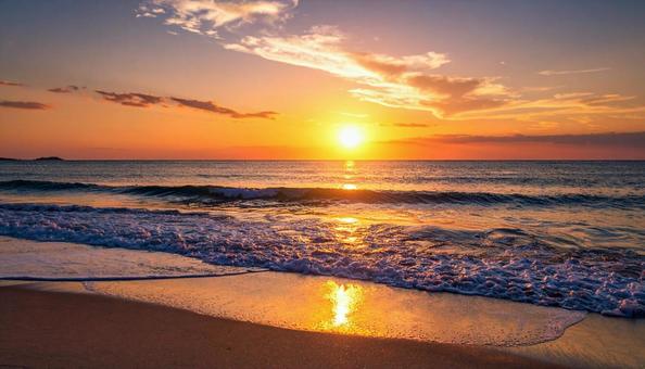 夕焼けの波打ち際・夕日のビーチサイドの写真