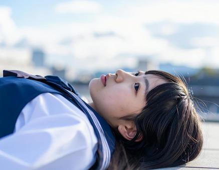 考えごとをしながら空を見つめる女子高生 考えごとをしながら空を見つめる女子高生の写真
