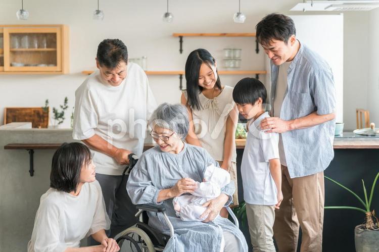 赤ちゃんと対面する高齢者女性と子供達 育児,出産,福祉の写真素材