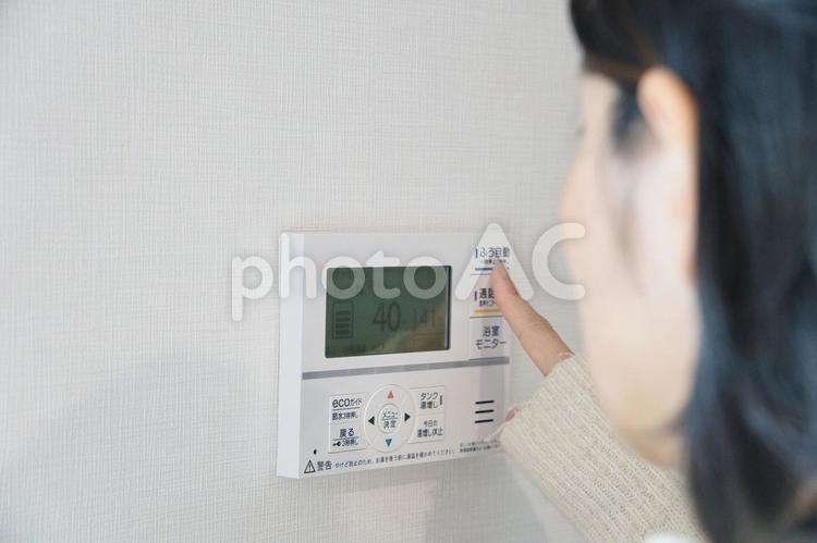給湯機を操作してお風呂にお湯をはる女性 女性,顔なし,給湯機の写真素材