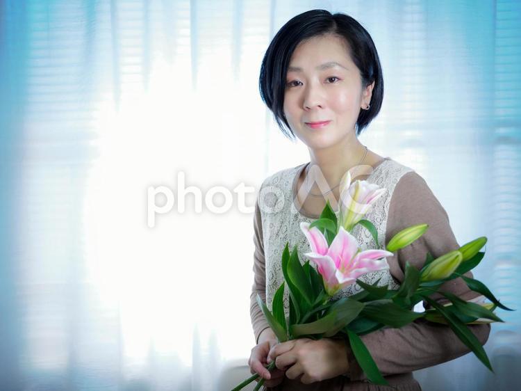 36：ゆりの花を抱いて微笑む女性 花,ゆり,丁寧な暮らしの写真素材