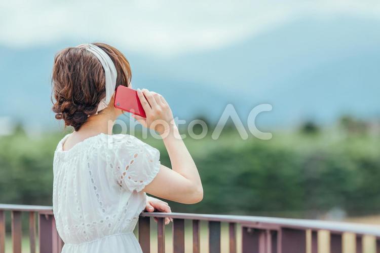 自然の中でスマホを持つ女性 スマホ,旅行,通話の写真素材