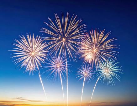 夕暮れの空を彩る色鮮やかな花火の競演 夕暮れの空を彩る色鮮やかな花火の競演の写真