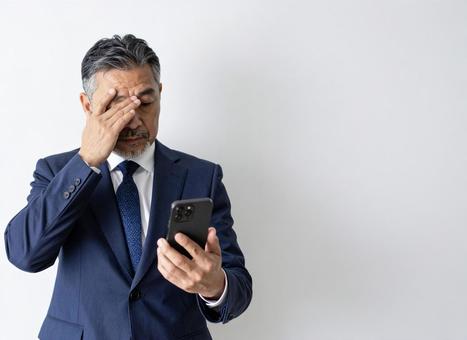 スマホ 60代 笑顔 悪い知らせ スマホ 60代 笑顔 悪い知らせ の写真