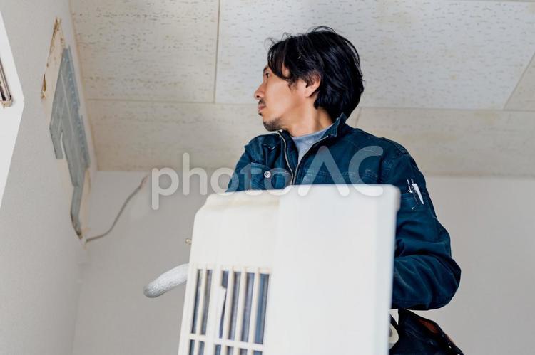 古いエアコンを外した電気工事作業員 ビジネス,ビジネスマン,男の写真素材