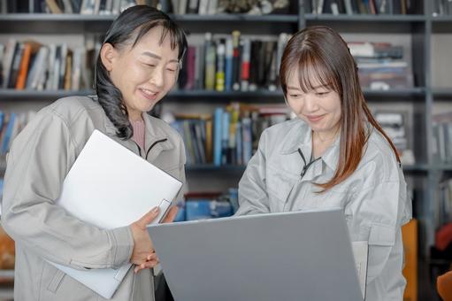 笑顔でPCを触る女性 笑顔でPCを触る女性 作業服,女性,笑顔の写真素材