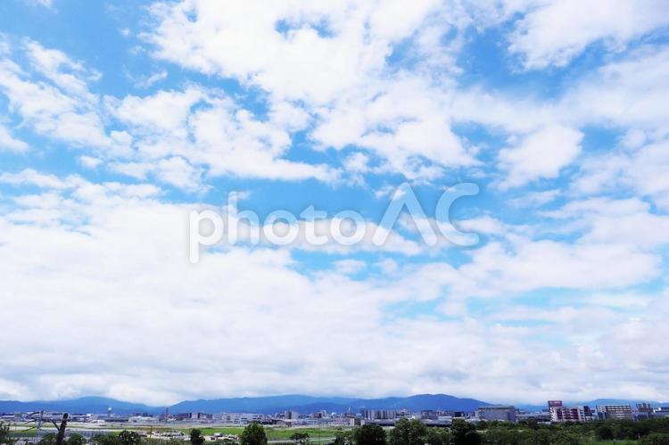 空に流れる白い雲と街並みのある空の背景 空,青空,背景の写真素材