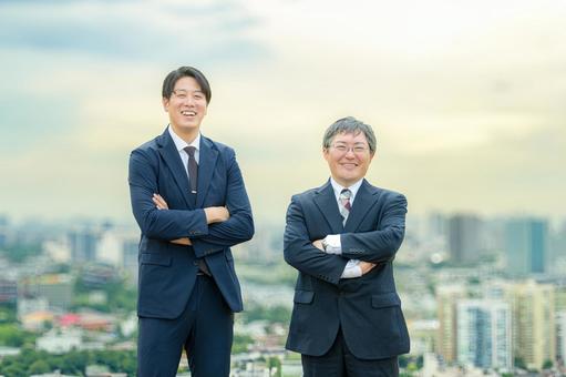 街並みと腕組みするビジネスマン 街並みと腕組みするビジネスマン 都市開発,ビジネスマン,スーツの写真素材