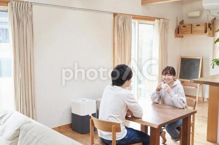 リビングで会話をするアジア人の夫婦 夫婦,会話,笑顔の写真素材