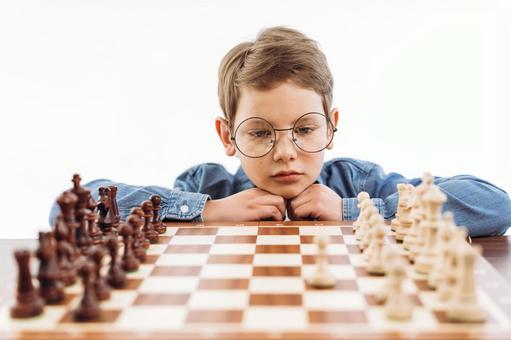 手に顎を乗せてチェスを見ている男の子(白背景) 手に顎を乗せてチェスを見ている男の子(白背景) チェス,子ども,男の子の写真素材