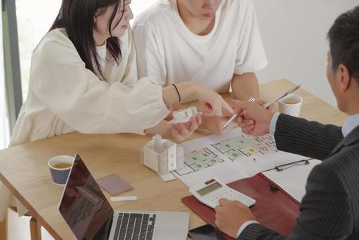 営業マンと家づくりの相談をする若い夫婦 営業マンと家づくりの相談をする若い夫婦 住宅,家,新築の写真素材