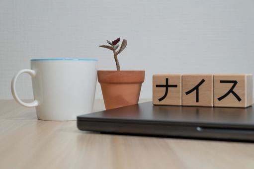ナイスの文字ブロックと休憩中のデスク小物 ナイス,コピースペース,成功の写真素材
