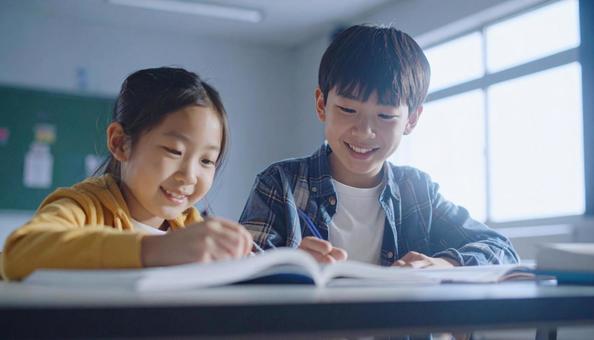 学校の教室で勉強している小学生2人の写真