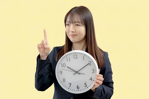 時計と指差すビジネス女性 管理,確認,注意の写真素材