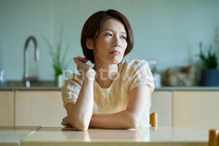 疲れを感じるミドル世代の女性 頭痛,女性,体調不良の写真素材