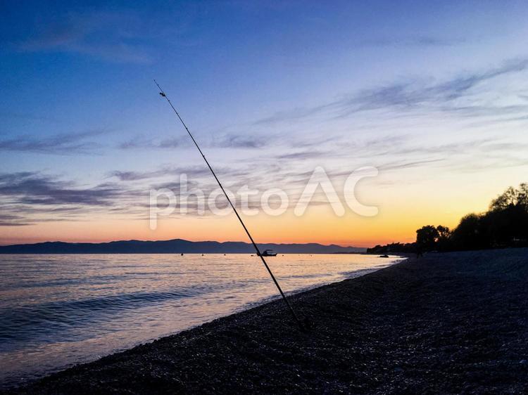 夕方の海岸と釣り竿 夕方,夕日,夕焼けの写真素材