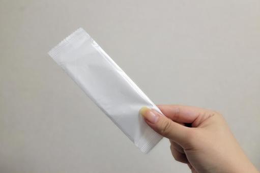 使い捨ておしぼりを手に持っている写真 手,おしぼり,手持ちの写真素材