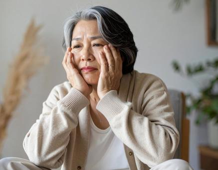 疲れた表情で休むシニアの日本人女性 疲れた表情で休むシニアの日本人女性の写真