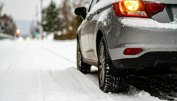 大雪が降った翌日の朝の道路を進む自動車 大雪が降った翌日の朝の道路を進む自動車の写真
