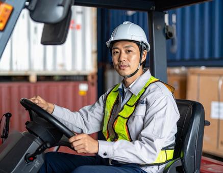 フォークリフトを運転する男性作業員の写真