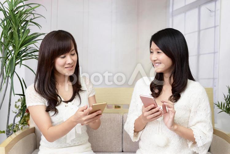 スマートフォンを持つ二人の女性 女性,女,笑顔の写真素材
