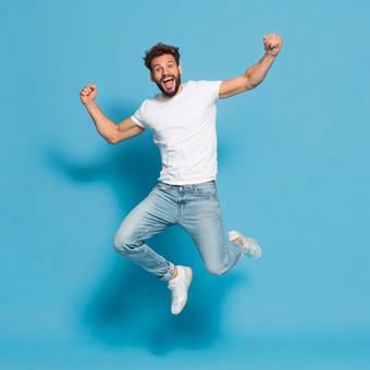 喜びを全身で表現し、高くジャンプする男性 喜びを全身で表現し、高くジャンプする男性の写真
