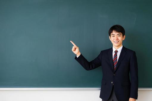 黒板を指差す男子高校生 黒板を指差す男子高校生の写真