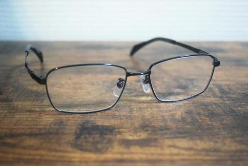木のテーブルに置かれた黒縁メガネ メガネ,黒縁,眼鏡の写真素材
