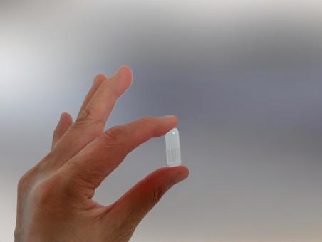 カプセルを手で持つ 薬,カプセル,カプセル錠の写真素材