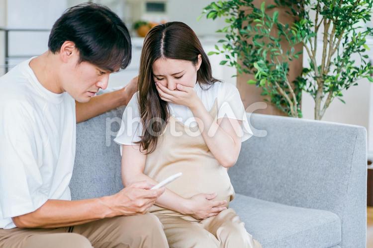 出産直前の妊婦の病院を探す男性（スマホ） 破水,陣痛,妊婦の写真素材