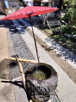 赤い和傘と湧き水 赤い和傘と湧き水の写真