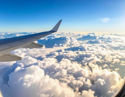 機内の窓から見える主翼と雲海 機内の窓から見える主翼と雲海の写真