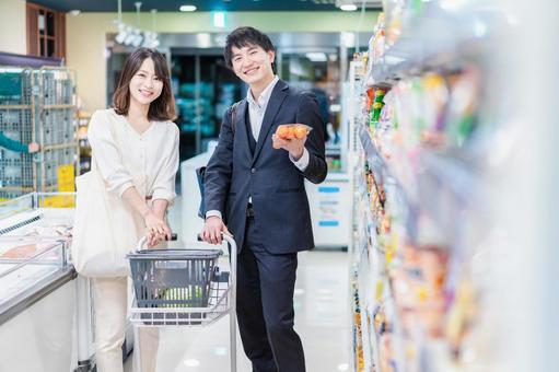 スーパーで食料品を買い物する若い夫婦 スーパーで食料品を買い物する若い夫婦の写真