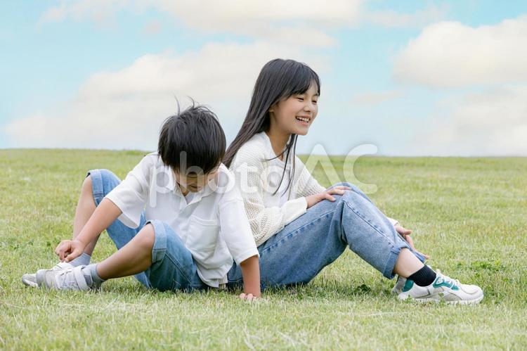 丘の上で仲良く微笑む子ども 笑顔,スマイル,子どもの写真素材
