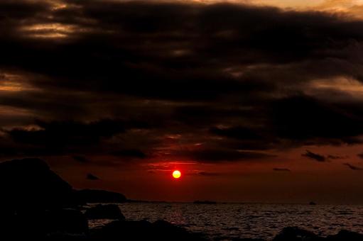 <素材>秋の暗い海へ沈む夕日 <素材>秋の暗い海へ沈む夕日の写真