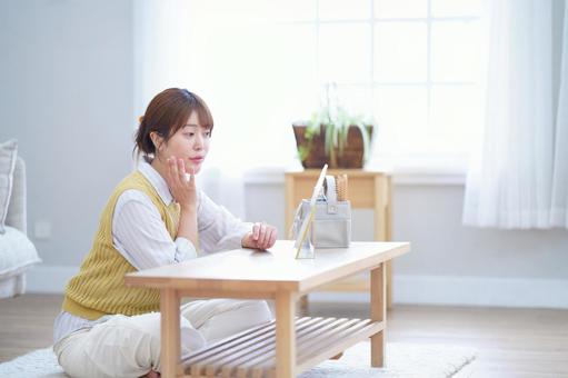 鏡を見ながら頬を触る女性 女性,頬,触るの写真素材