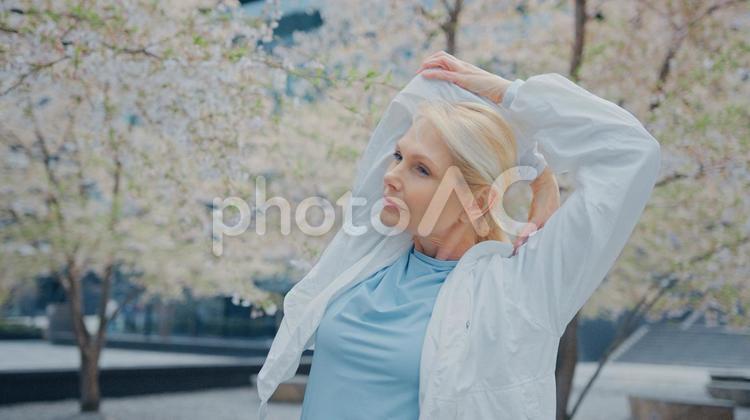 頭の後ろで肘を伸ばす女性 女性,人物,元気の写真素材