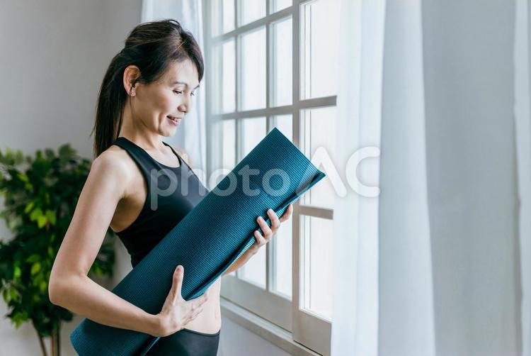 ヨガマットを持つミドル世代の女性 ヨガ,ヨガマット,ダイエットの写真素材
