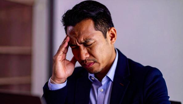 頭を押さえて悩む日本人男性ビジネスマン 頭を押さえて悩む日本人男性ビジネスマンの写真