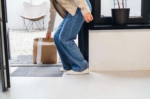 置き配された紙袋を取る女性 配達,フードデリバリー,デリバリーの写真素材