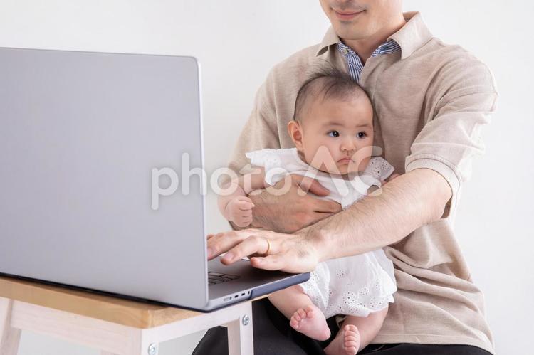 子どもをお世話しながら仕事する男性 赤ちゃん,ベビー,育児の写真素材