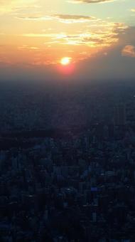 沈みゆく夕陽に灯し始める街の明かり 沈みゆく夕陽に灯し始める街の明かり 空,街,夕日の写真素材
