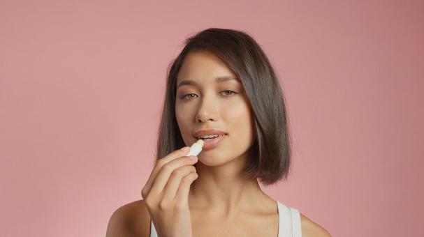 リップクリームを塗っているカメラ目線の女性 女性,外国人,アジア人の写真素材