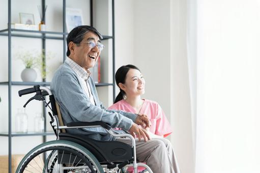 車椅子のシニアの男性と介護福祉士 車椅子のシニアの男性と介護福祉士 介護,シニア,男性の写真素材