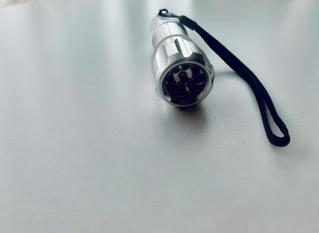 懐中電灯と白いテーブル 懐中電灯,ハンディライト,ライトの写真素材