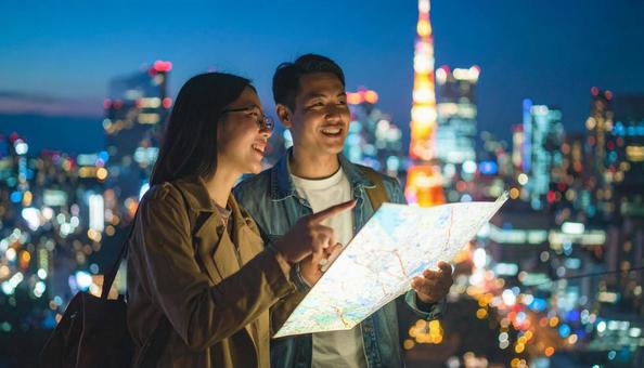ホログラムの地図を見ながら旅行観光 男女 ホログラムの地図を見ながら旅行観光 男女の写真