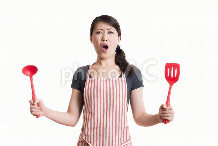 料理用具を持って変わった表情をする女性 1人,アジア人,イメージの写真素材